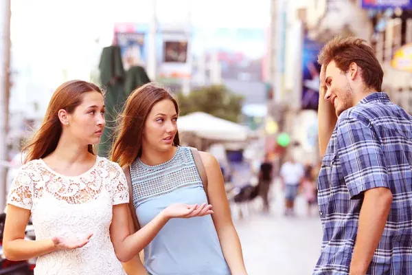 Homem abordando duas mulheres na rua